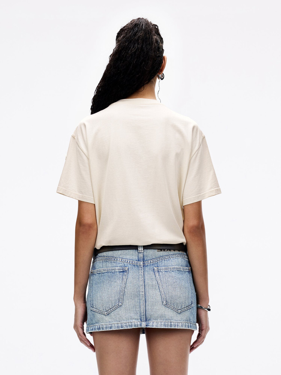camiseta adornada con tachuelas de perlas